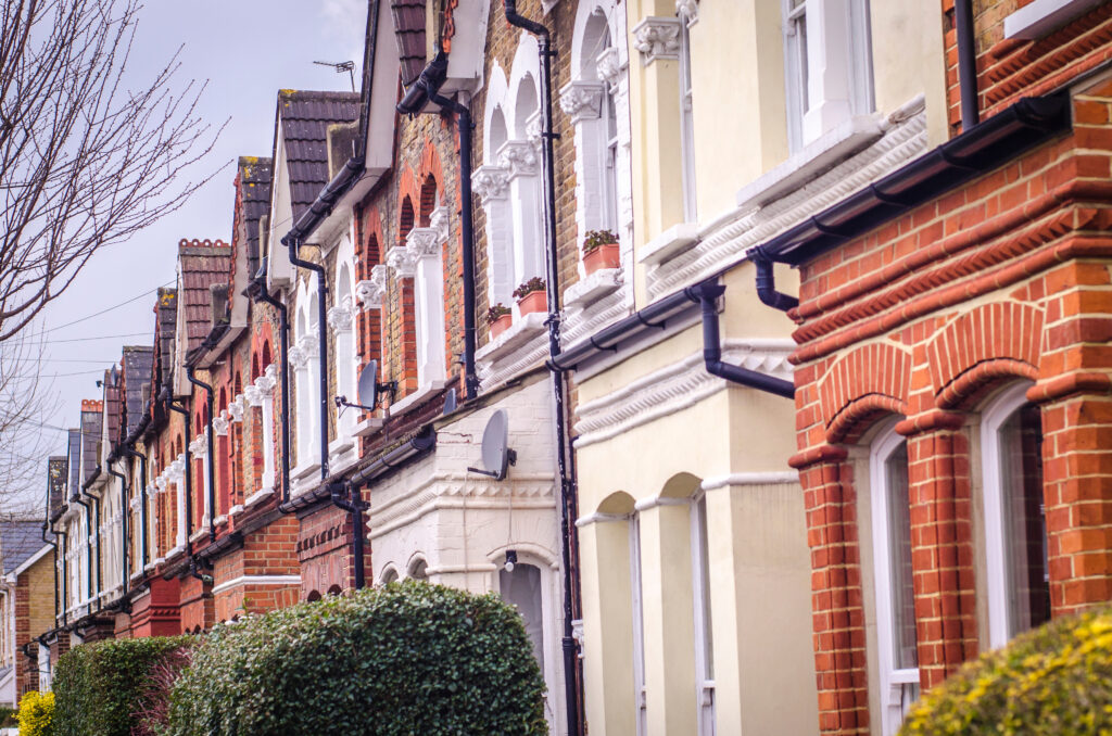 A row of British terraced houses on a cloudy day.