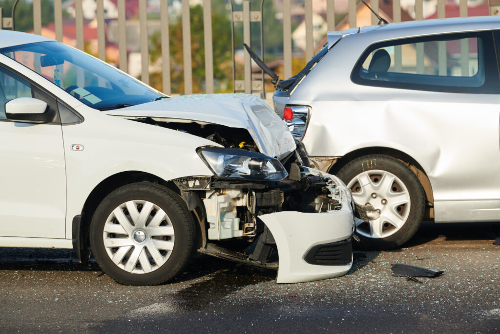 Two white cars appear to be heavily damaged after crashing into each other.