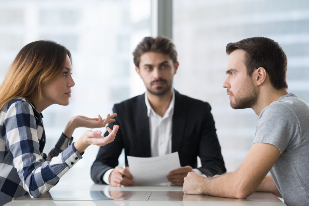 An unhappy married couple argue while they consult a solicitor on getting a divorce.