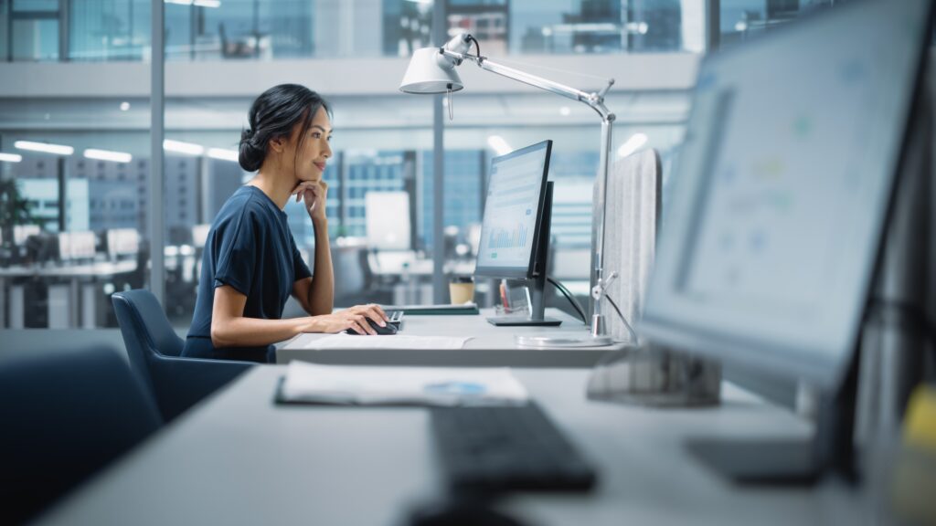 A young woman works to handle her client's claim in a modern office.