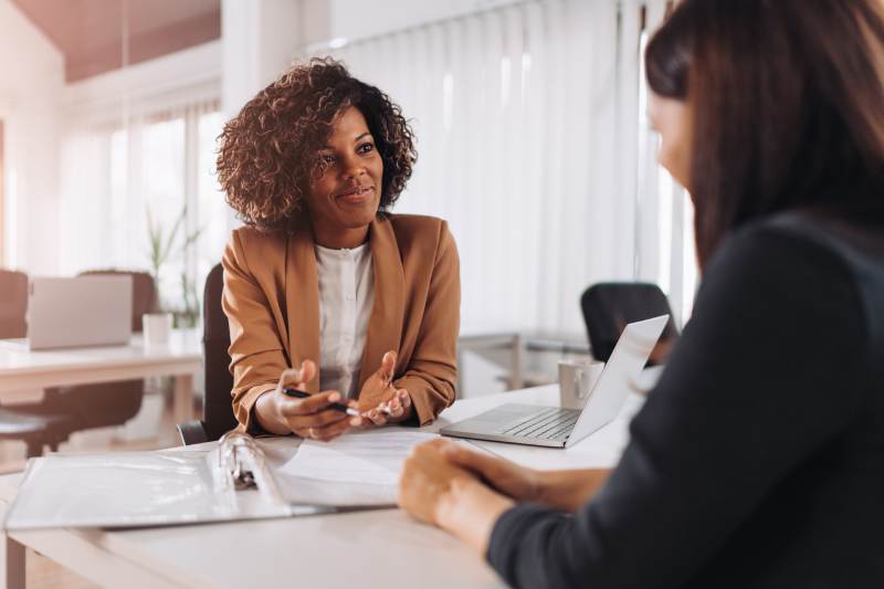 A smiling solicitor advises a client on an employment tribunal