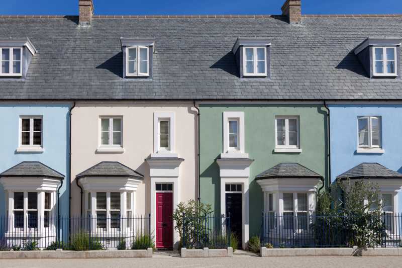 A row of colourful English terraced houses on a sunny day.